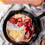 Dutch Baby in a cast iron skillet with fresh strawberries