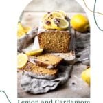 Lemon Cardamom Olive oil cake on a wooden cutting board with lemon slices on top.