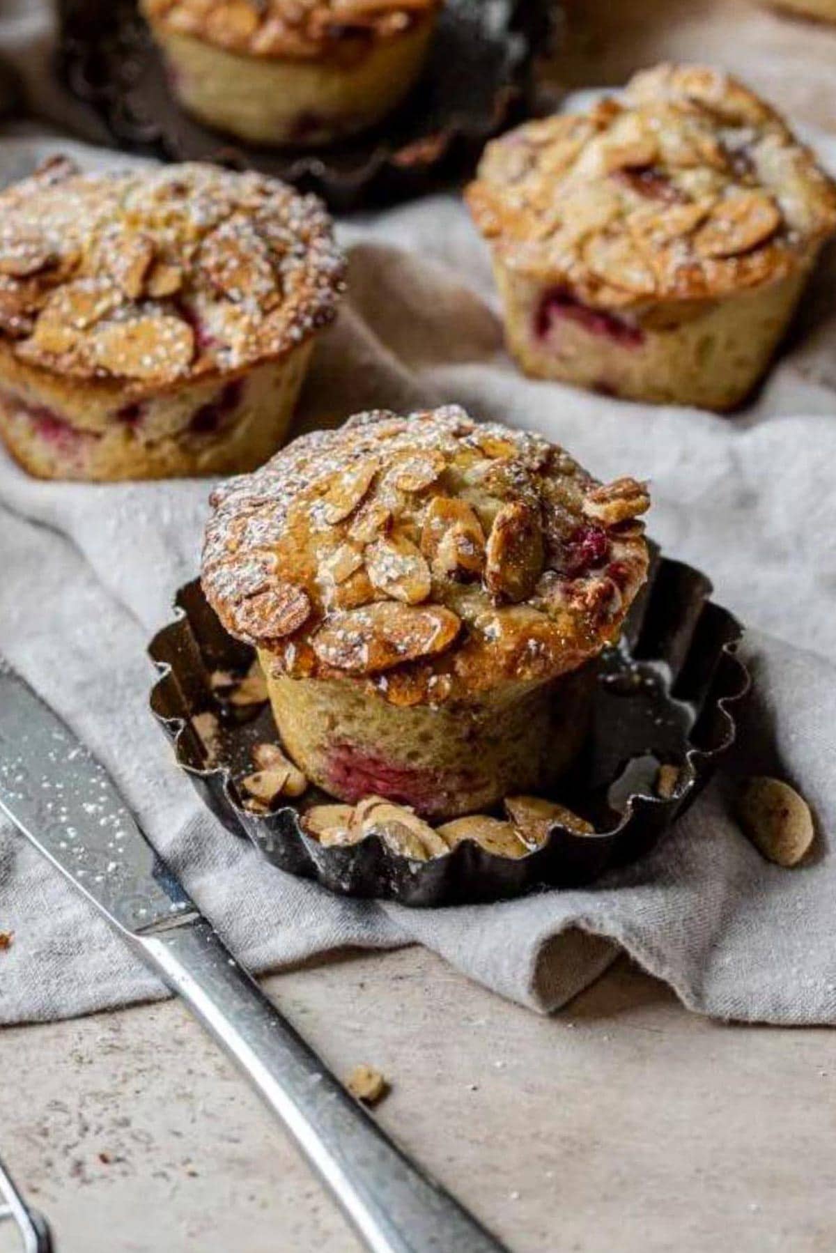 Raspberry almond muffin on a gray linen.