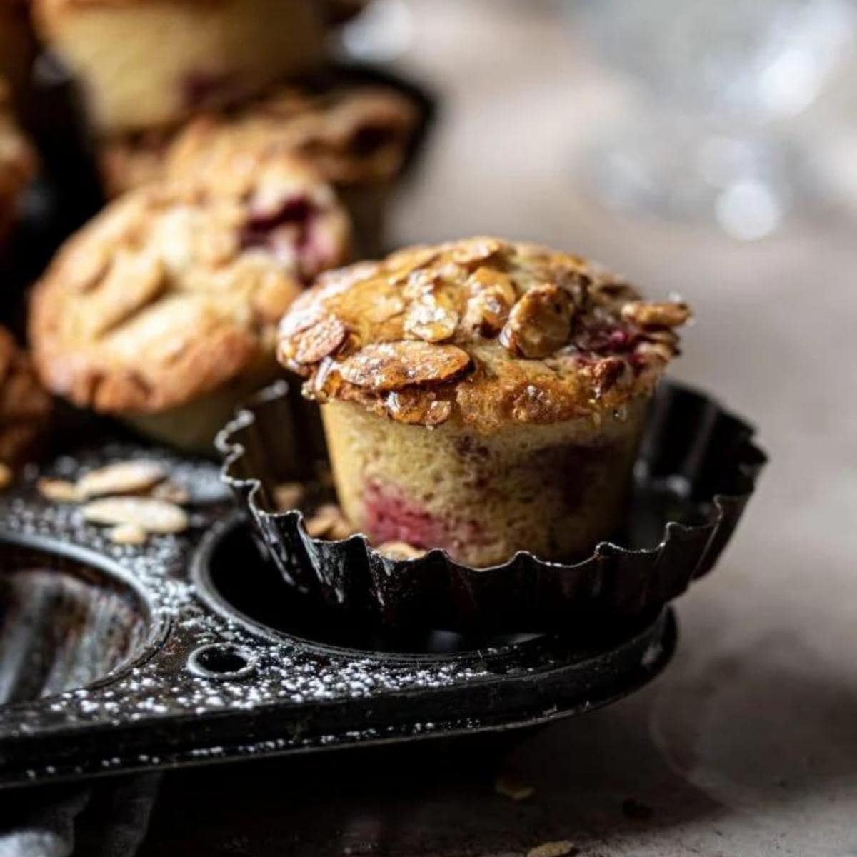 Raspberry almond muffin on a vintage muffin tray.