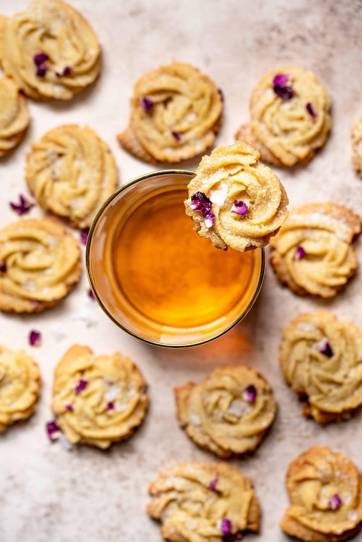 Shortbread cookies lined up around a glass of bourbon