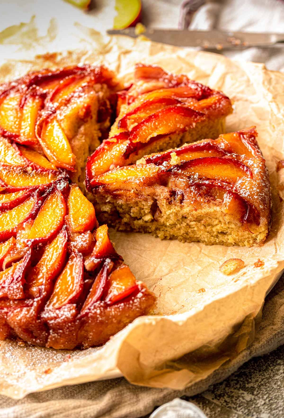 Peach upside down cake with slices cut out showing the cake texture.