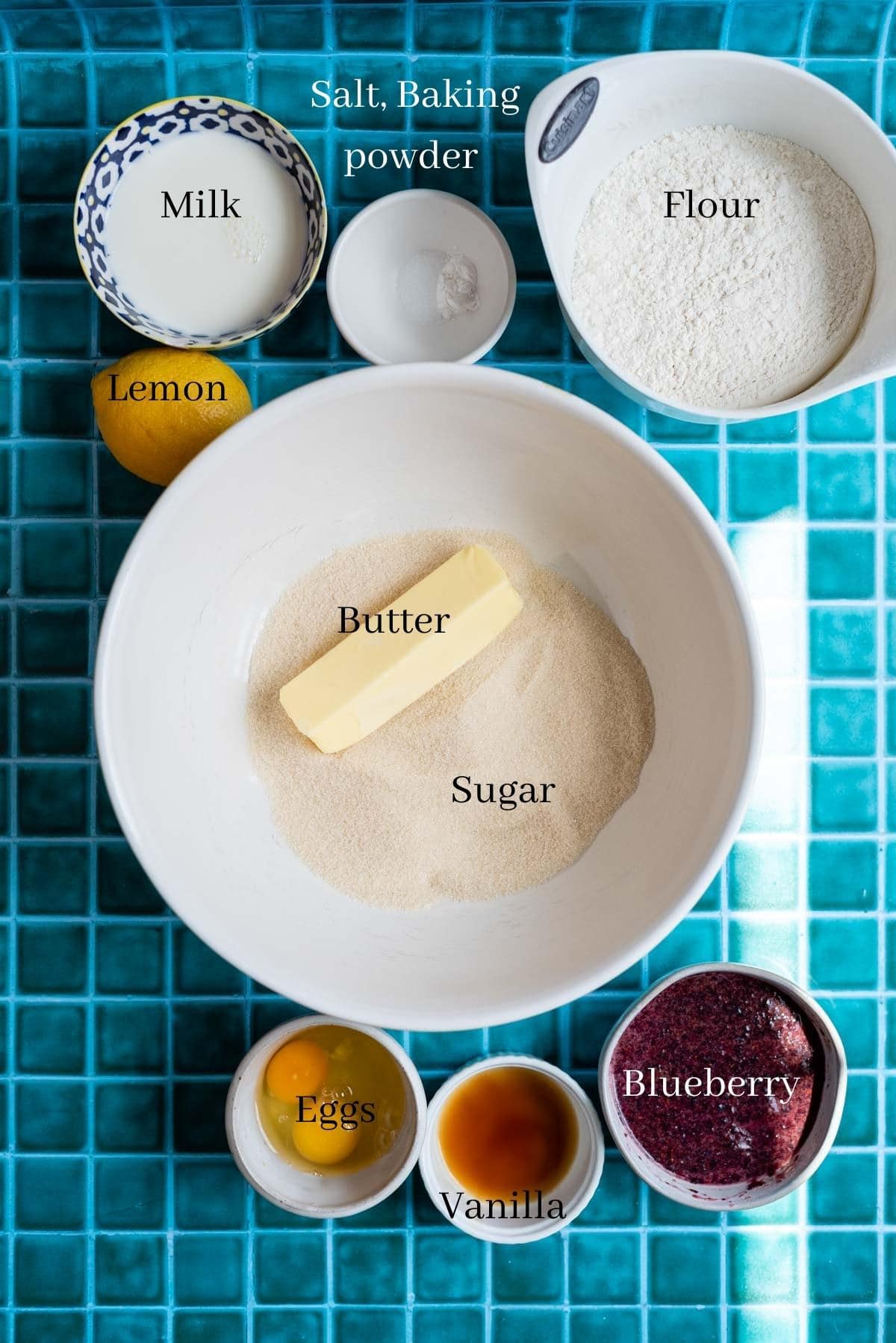 Blueberry cake ingredients on a green tile table.