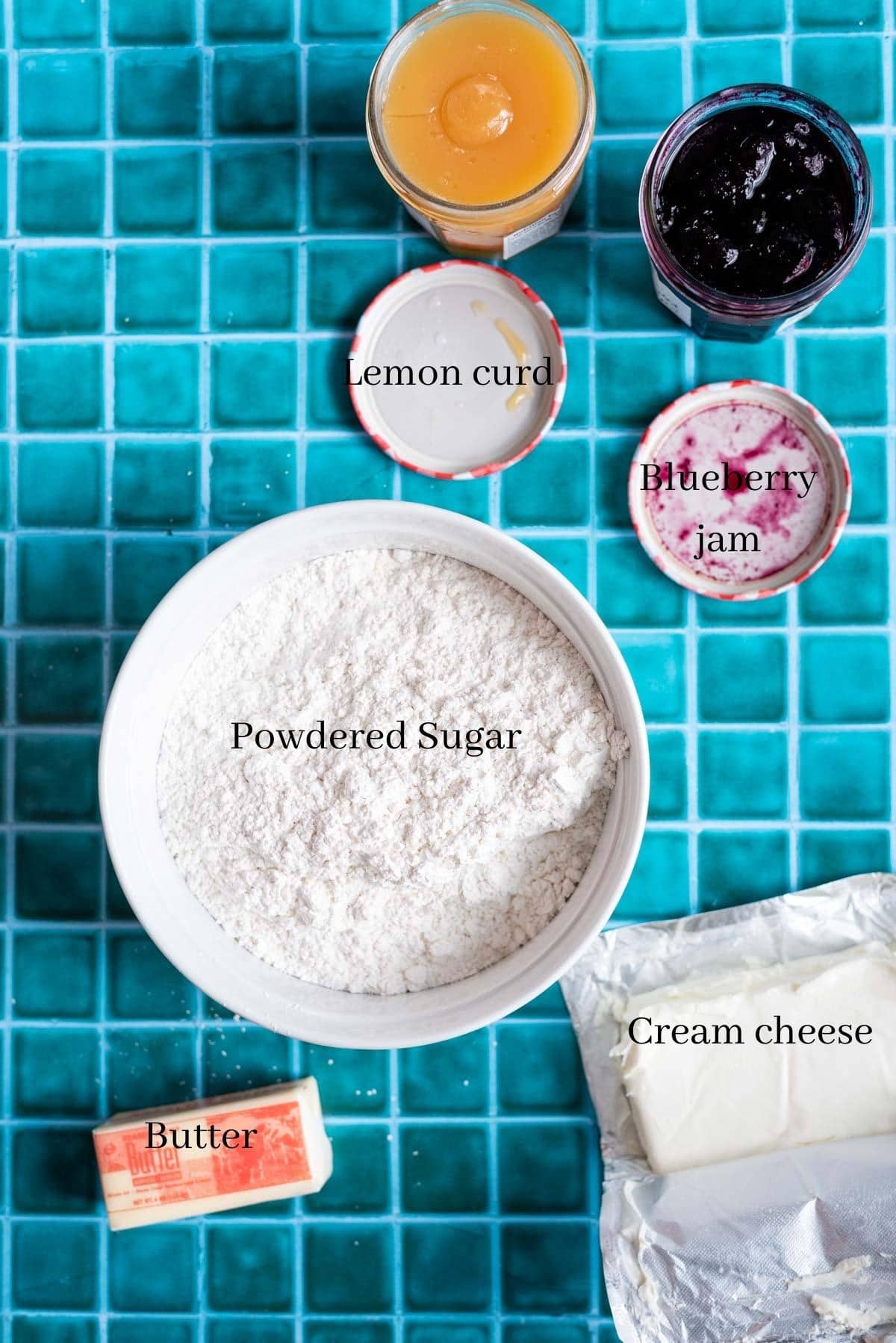 Blueberry icing ingredients on a green tile table.