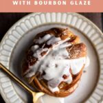 Cardamom bun with bourbon glaze drizzled on top on a plate with a spoon