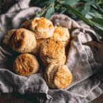 Buttermilk biscuits wrapped in linen on a wood table