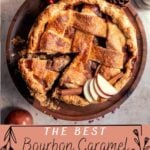 caramel apple pie on a wood cake stand surrounded by apples and pine cones