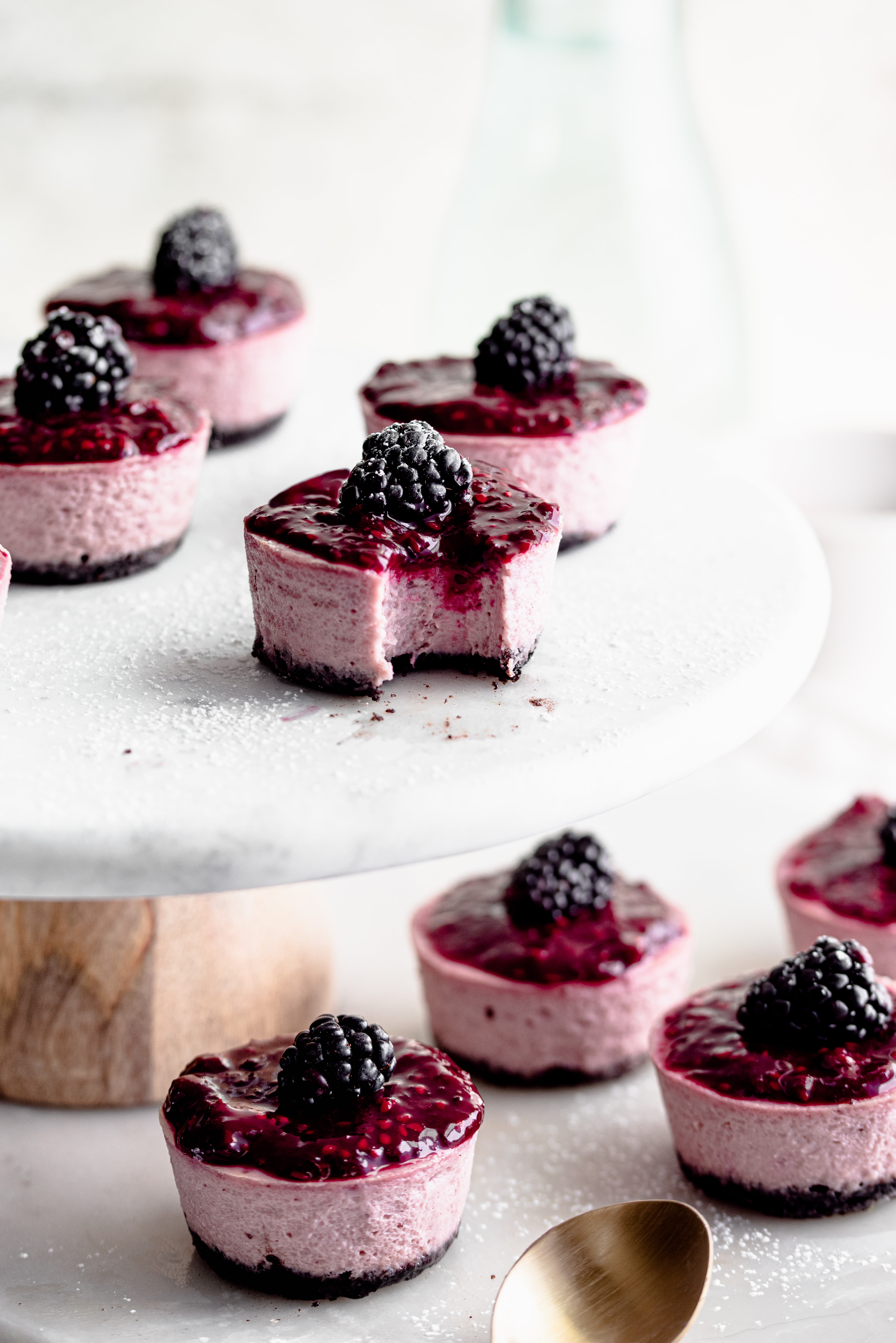 Blackberry mini cheesecakes with a bite tased out of one. 