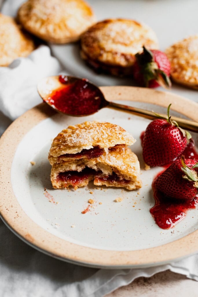 strawberry hand pies stacked on a plate