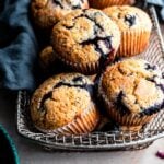 Muffins in a woven metal container with a blue linen.