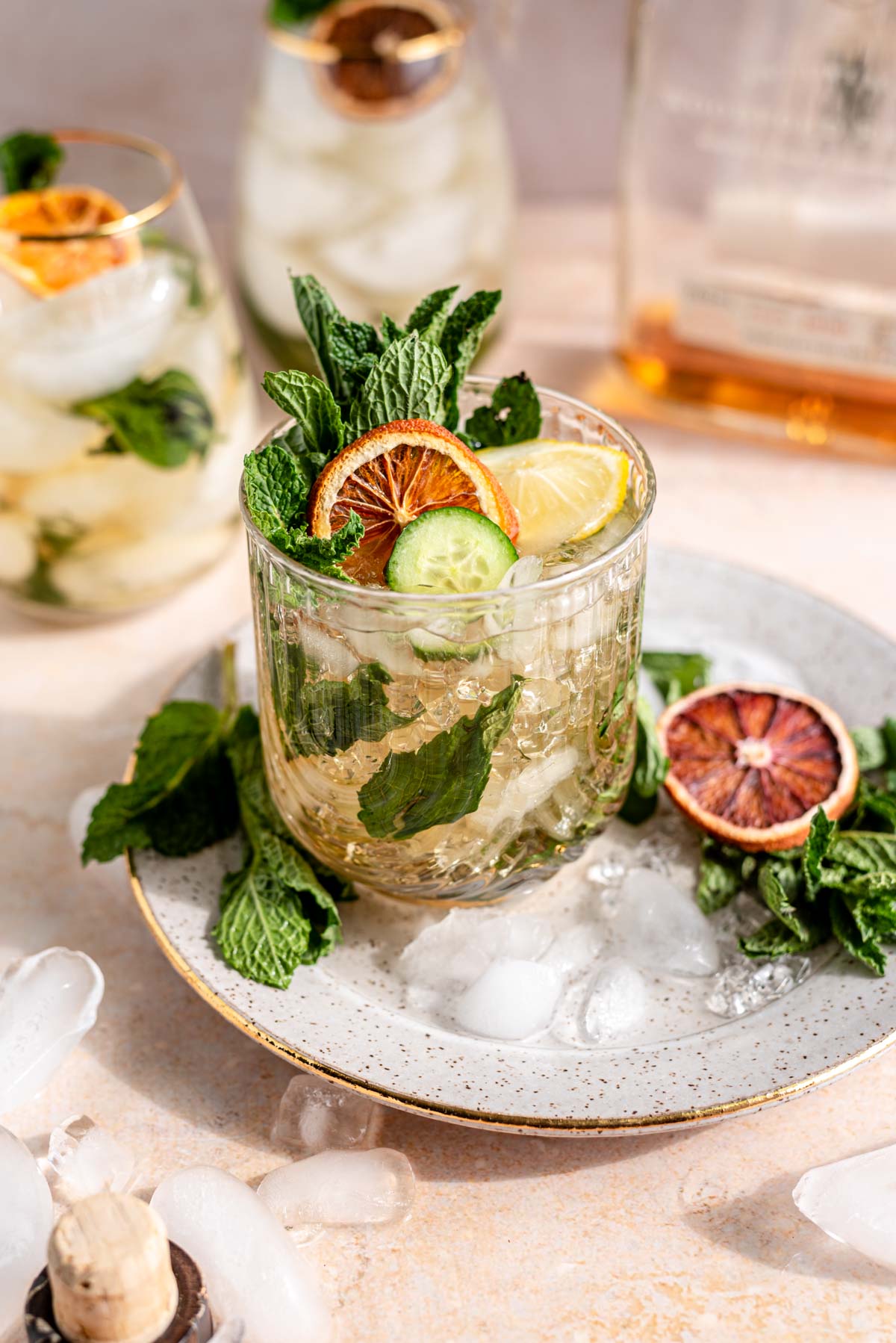 Mint julep in a clear glass surrounded by ice and mint.