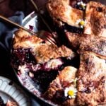 Blackberry pie in a silver pie pan with a fork in the pan as well