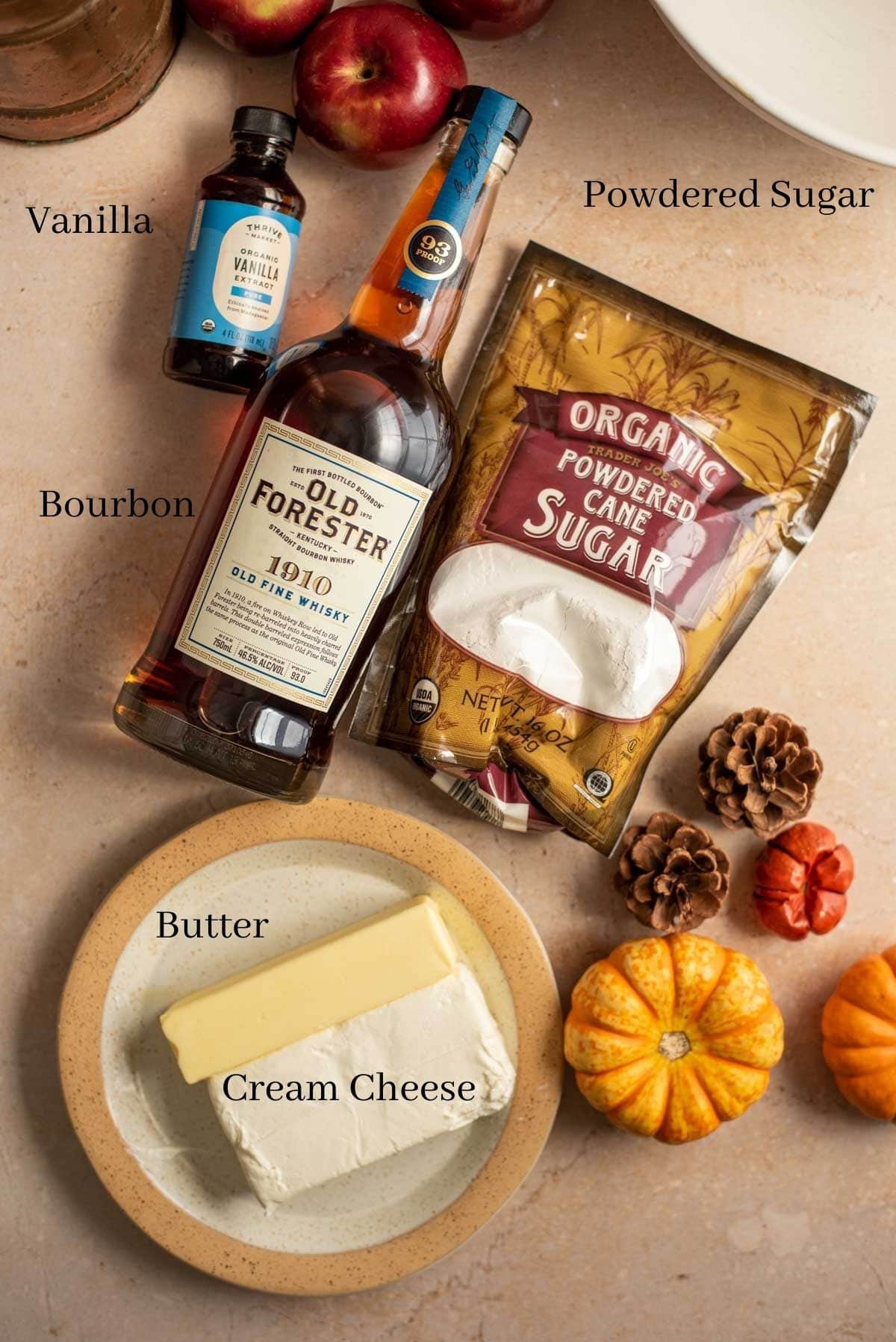 Ingredients for the bourbon icing on a brown stone table with some fall decor.