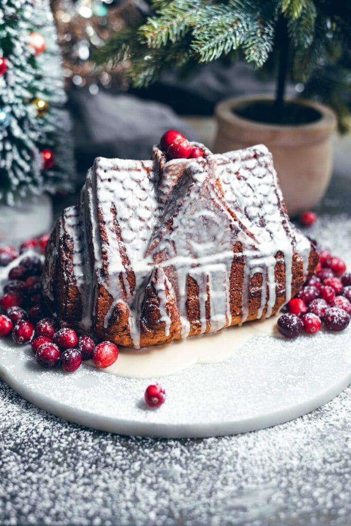 House shipped gingerbread bunt cake on a marble platter with cranberries