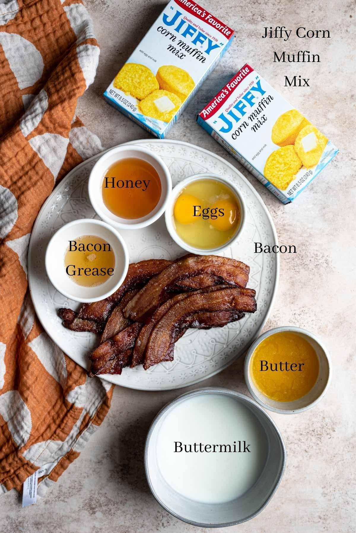 The ingredients for bacon corn muffins displayed on a brown table.