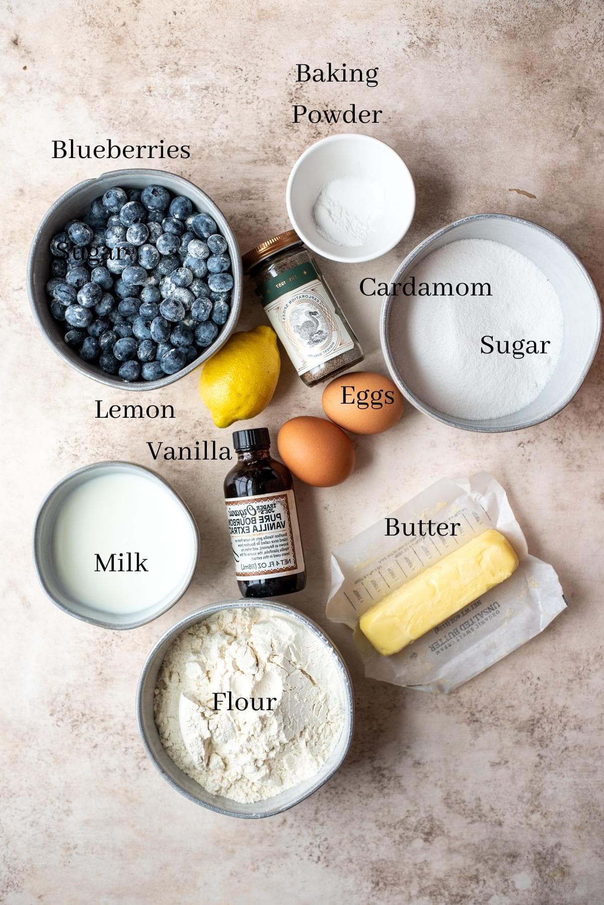 Ingredients for blueberry muffins on a brown table.