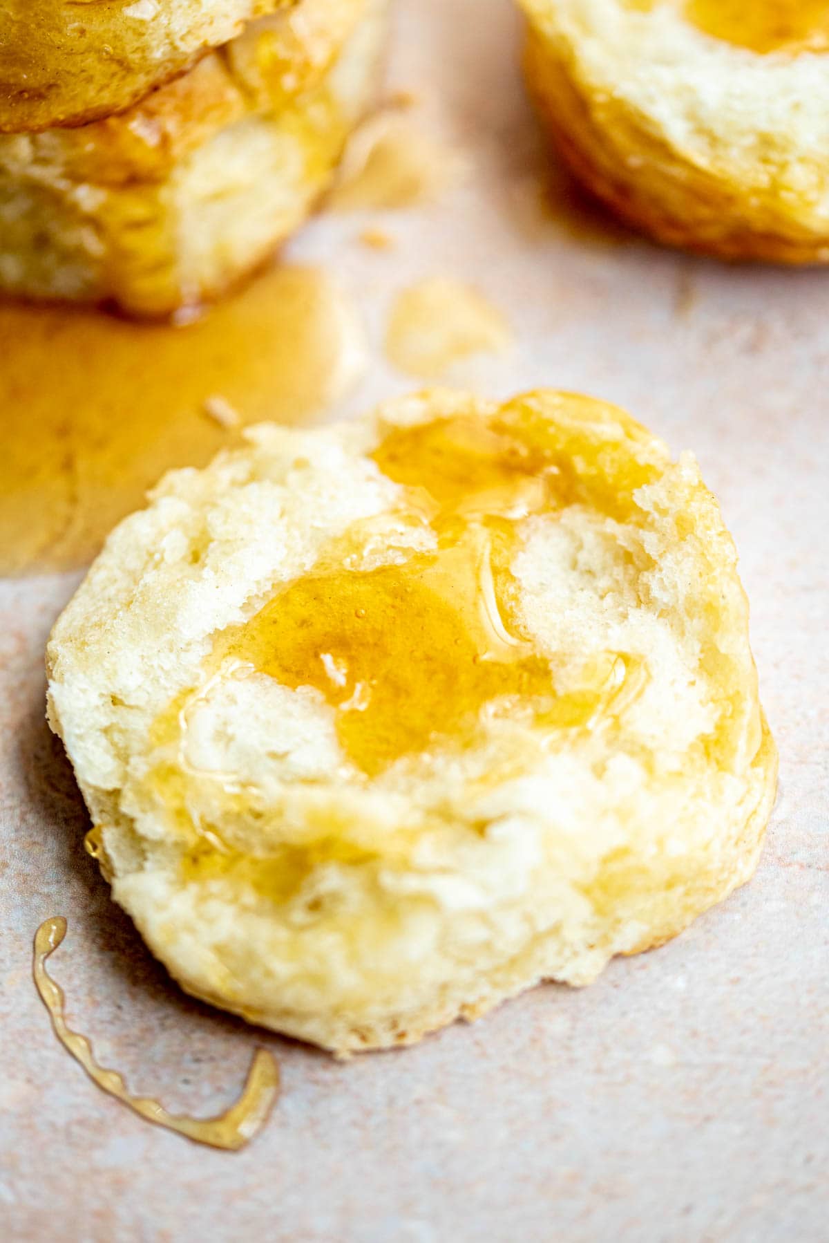 A biscuit split in half and drizzled with honey.