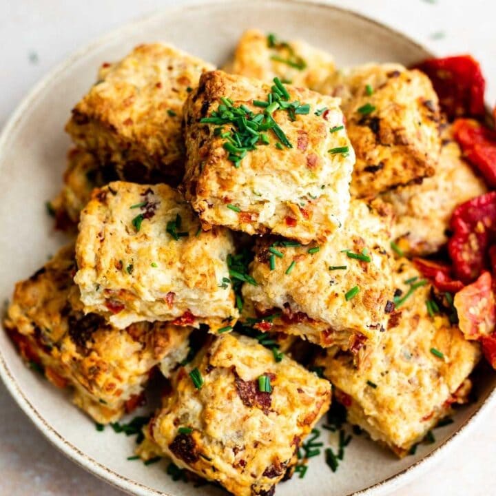 Sundried tomato biscuits pilled into three layers in a beige bowl.