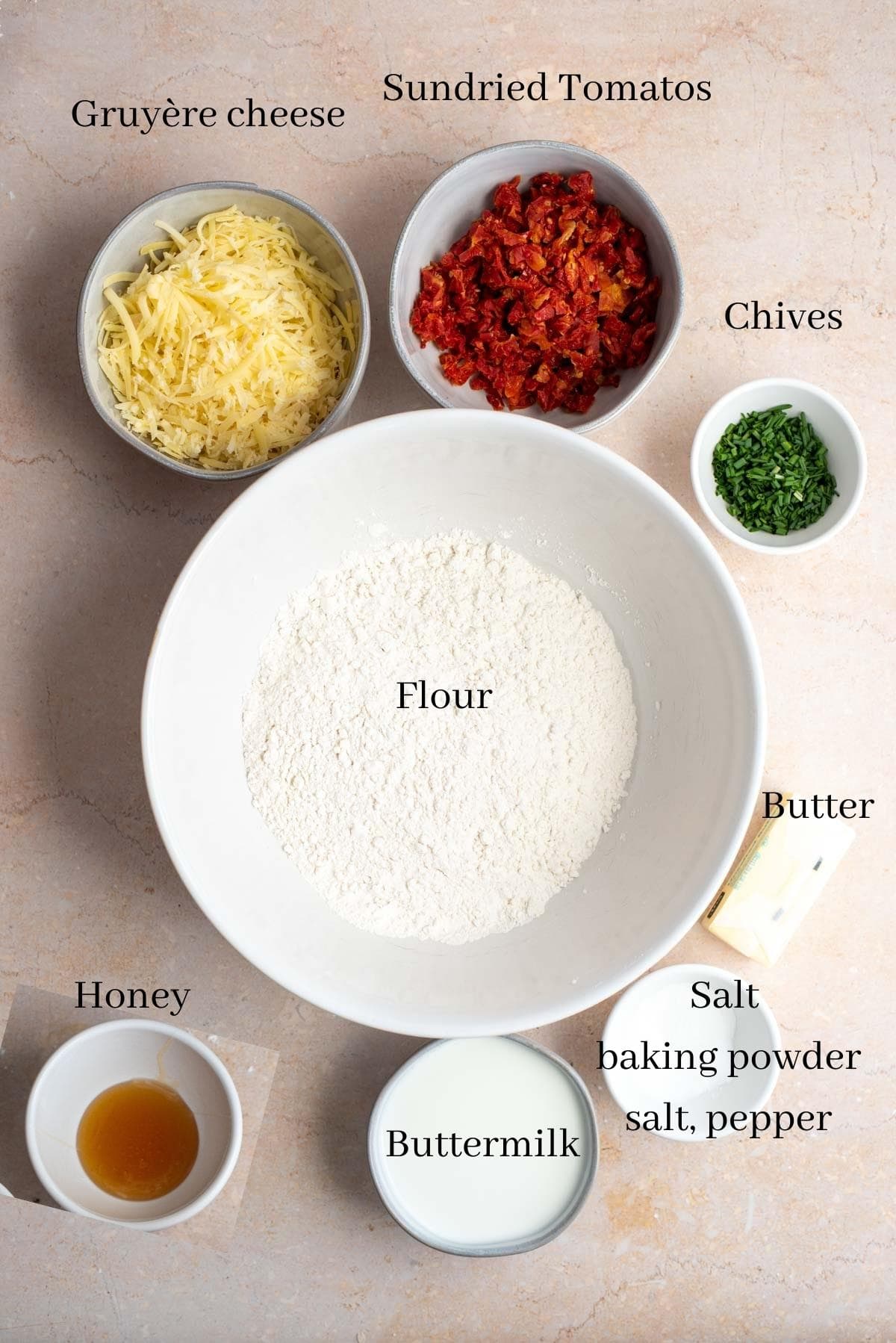 Ingredients for the sundried tomato biscuits on a brown table.
