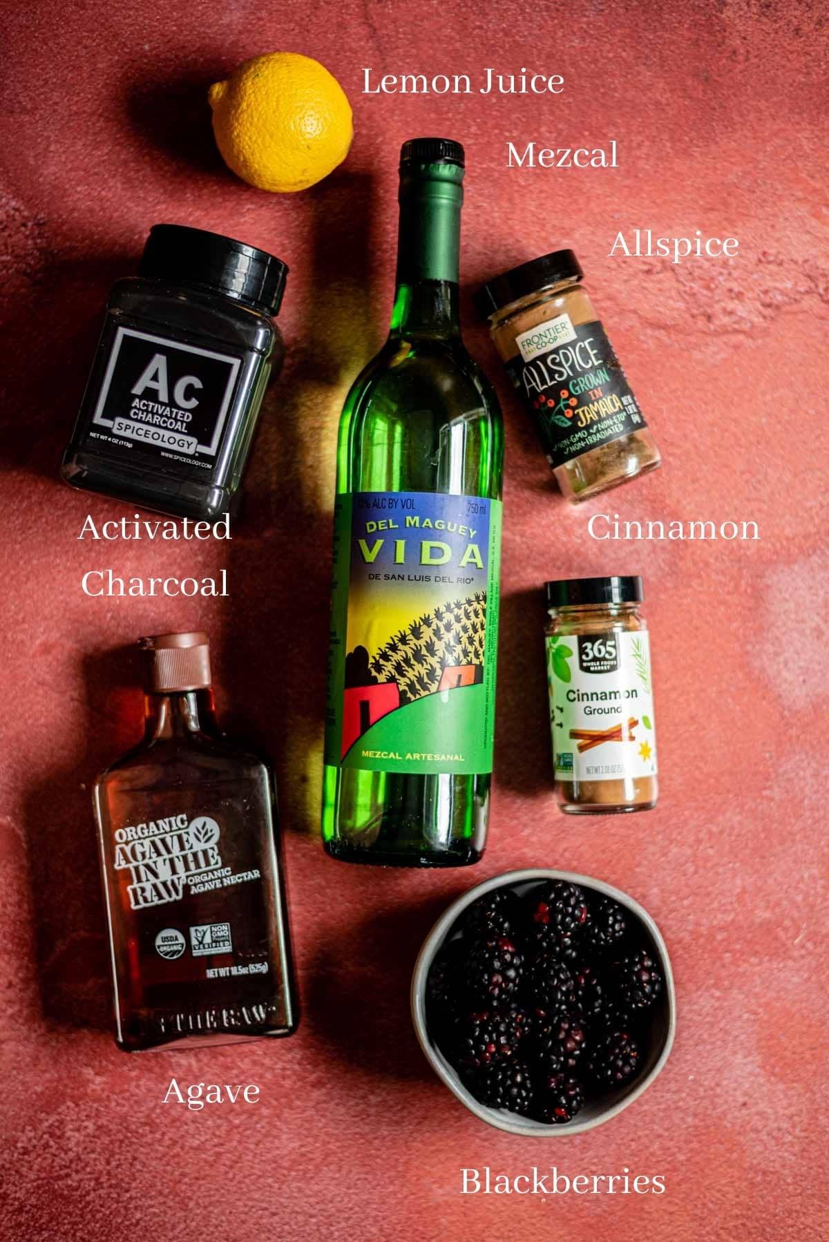 Ingredients for the cocktail on a red stone table.