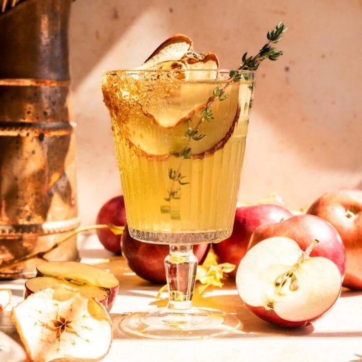 Thanksgiving sparking margarita garnished with apple slices and thyme.