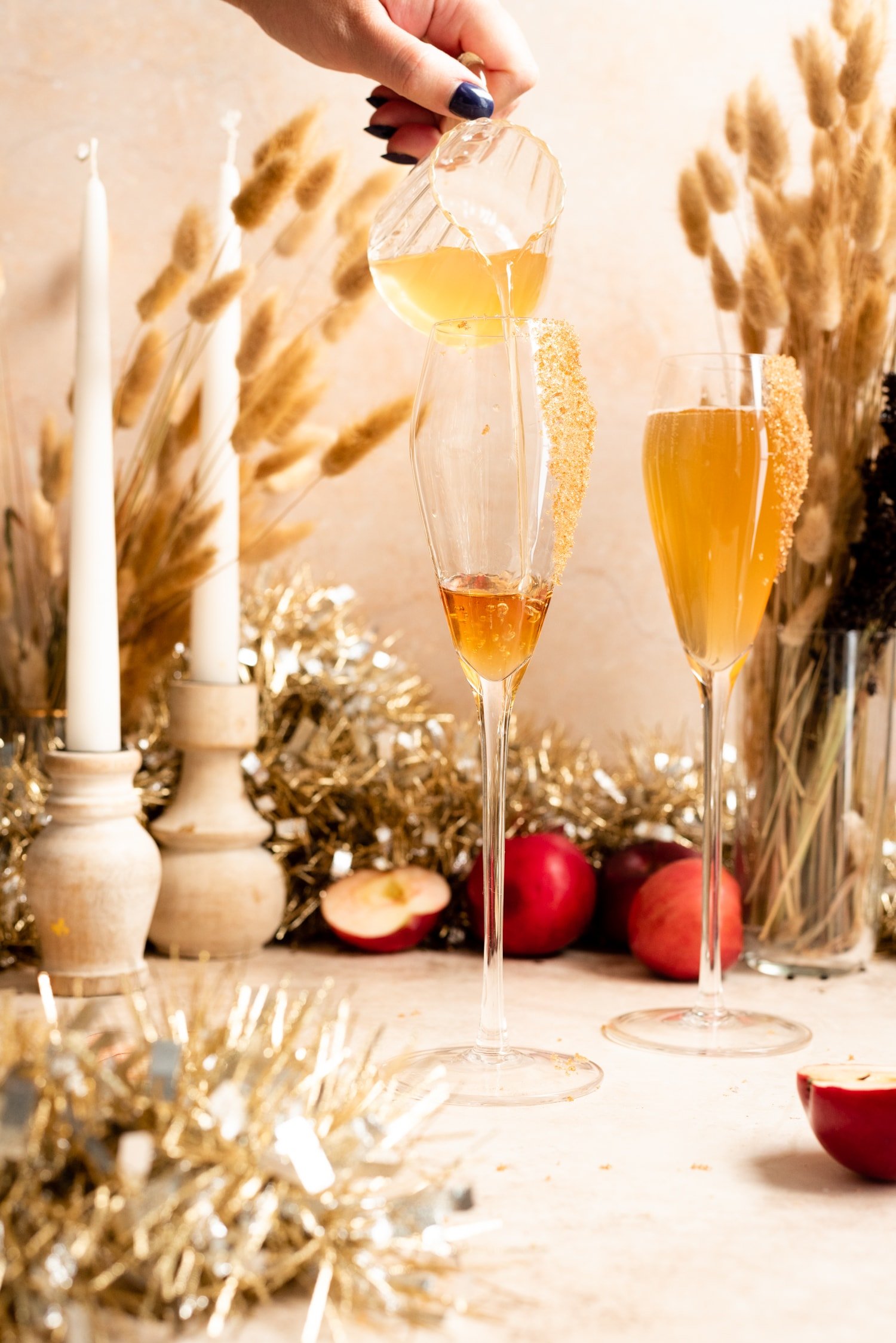 Apple cider being poured into the champagne flute.
