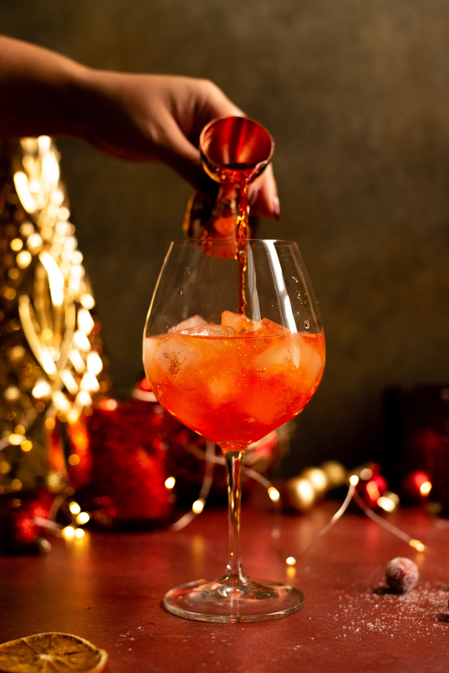 The aperol being poured on top of the processo and ice.