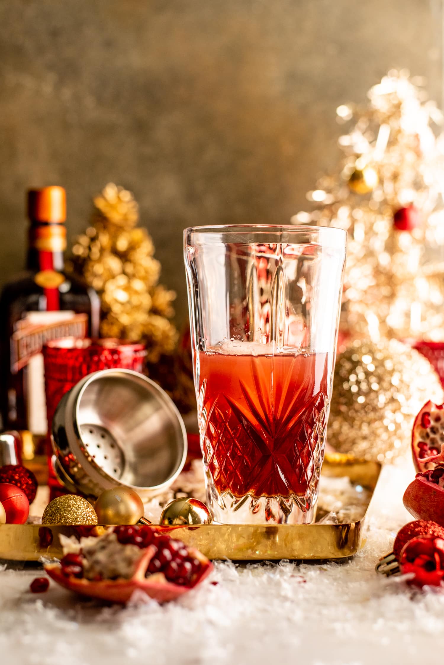 The shaken cocktail sitting on a table surrounded by ornaments.