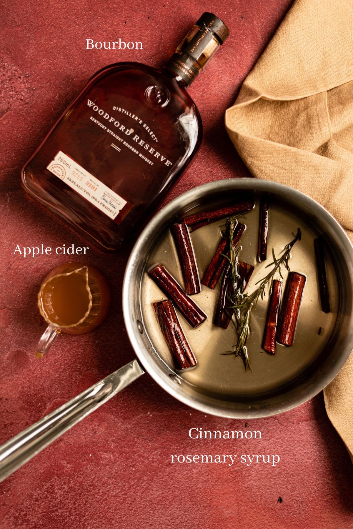 The ingredients for the old fashioned on a red table.