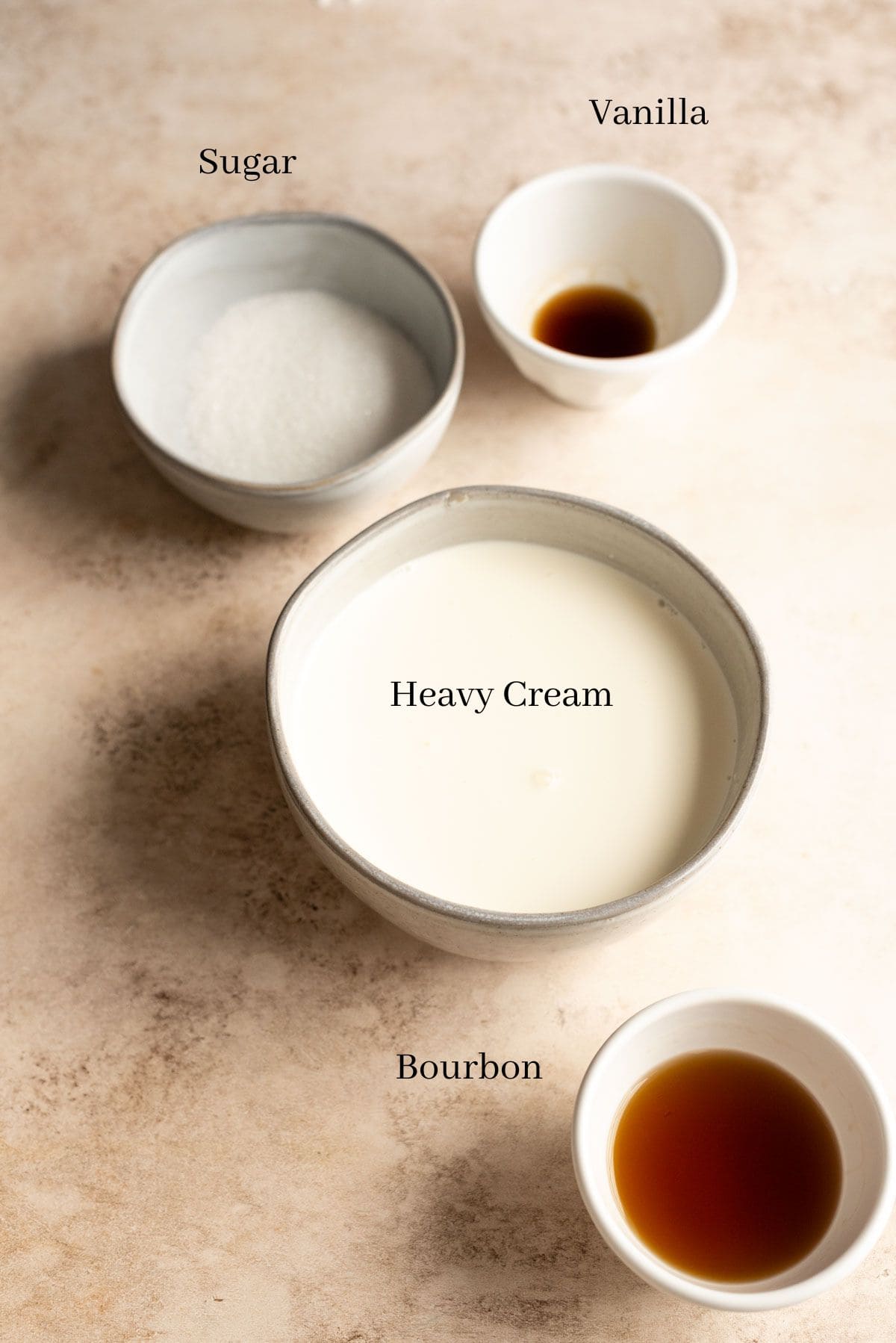 The ingredients for the bourbon whipped cream on a brown table.