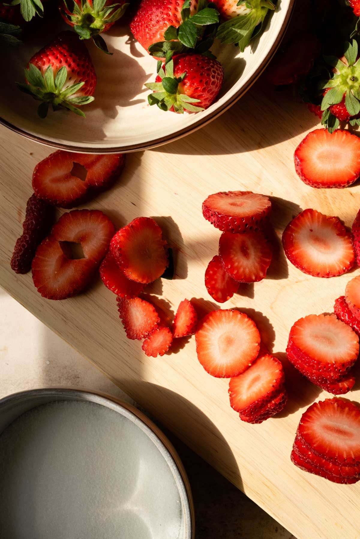 Sliced Strawberries on a cutting board.
