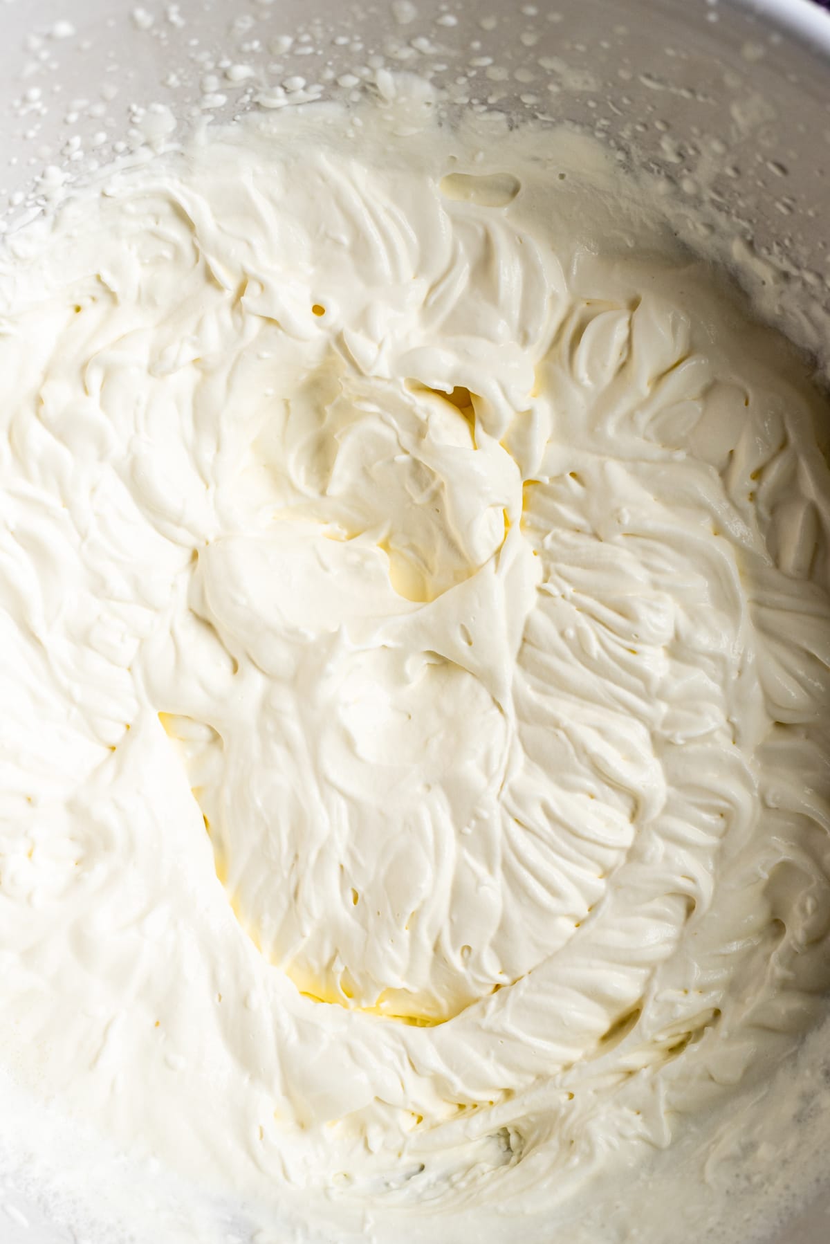 A close up shot of whipped cream whipped to stiff peaks.
