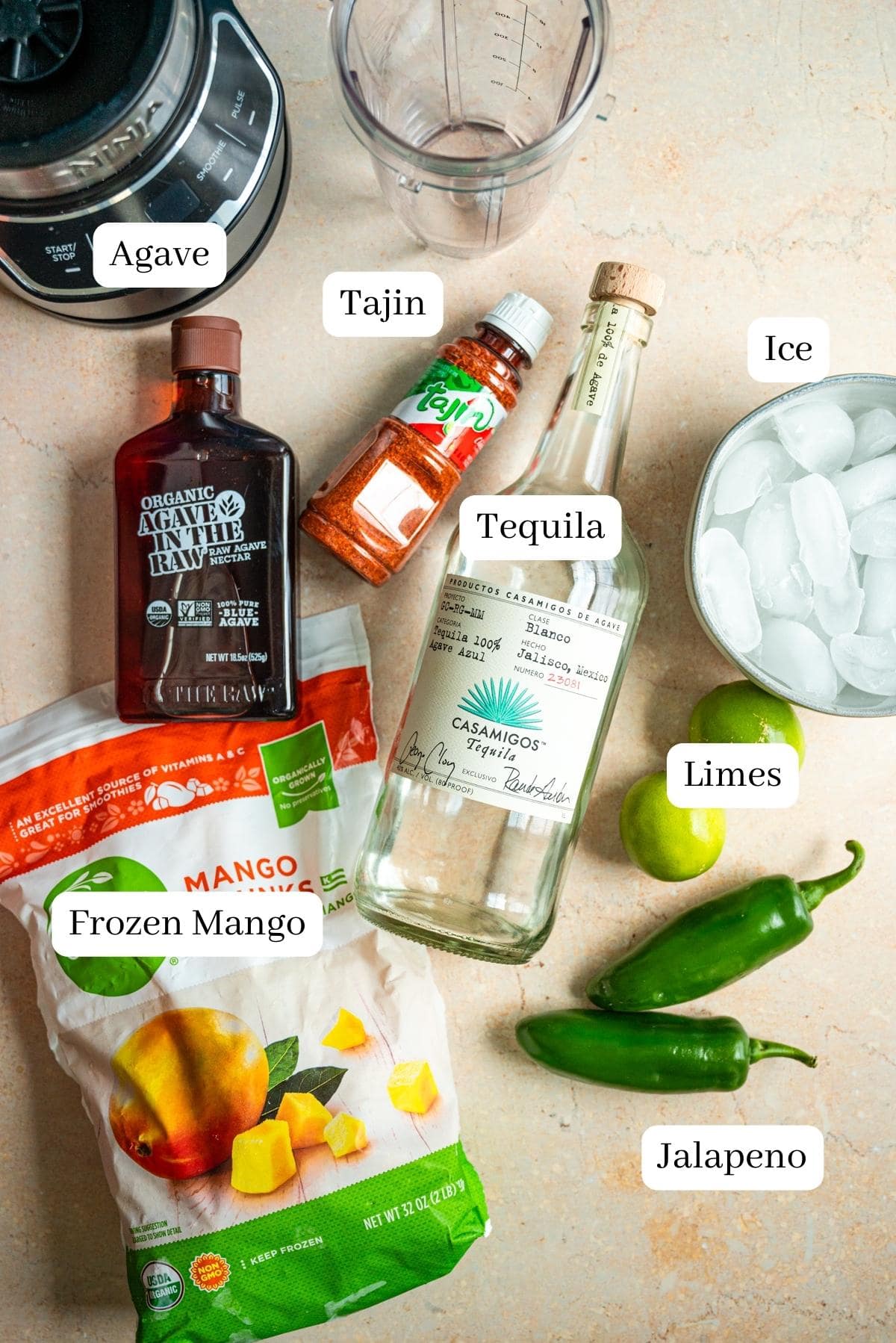 The ingredients for the margarita on a brown marble table.