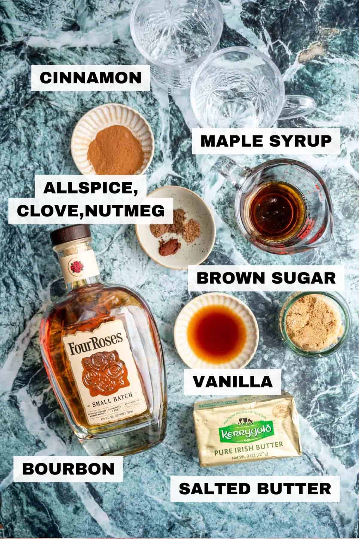 Ingredients for the hot buttered bourbon on a green marble table.