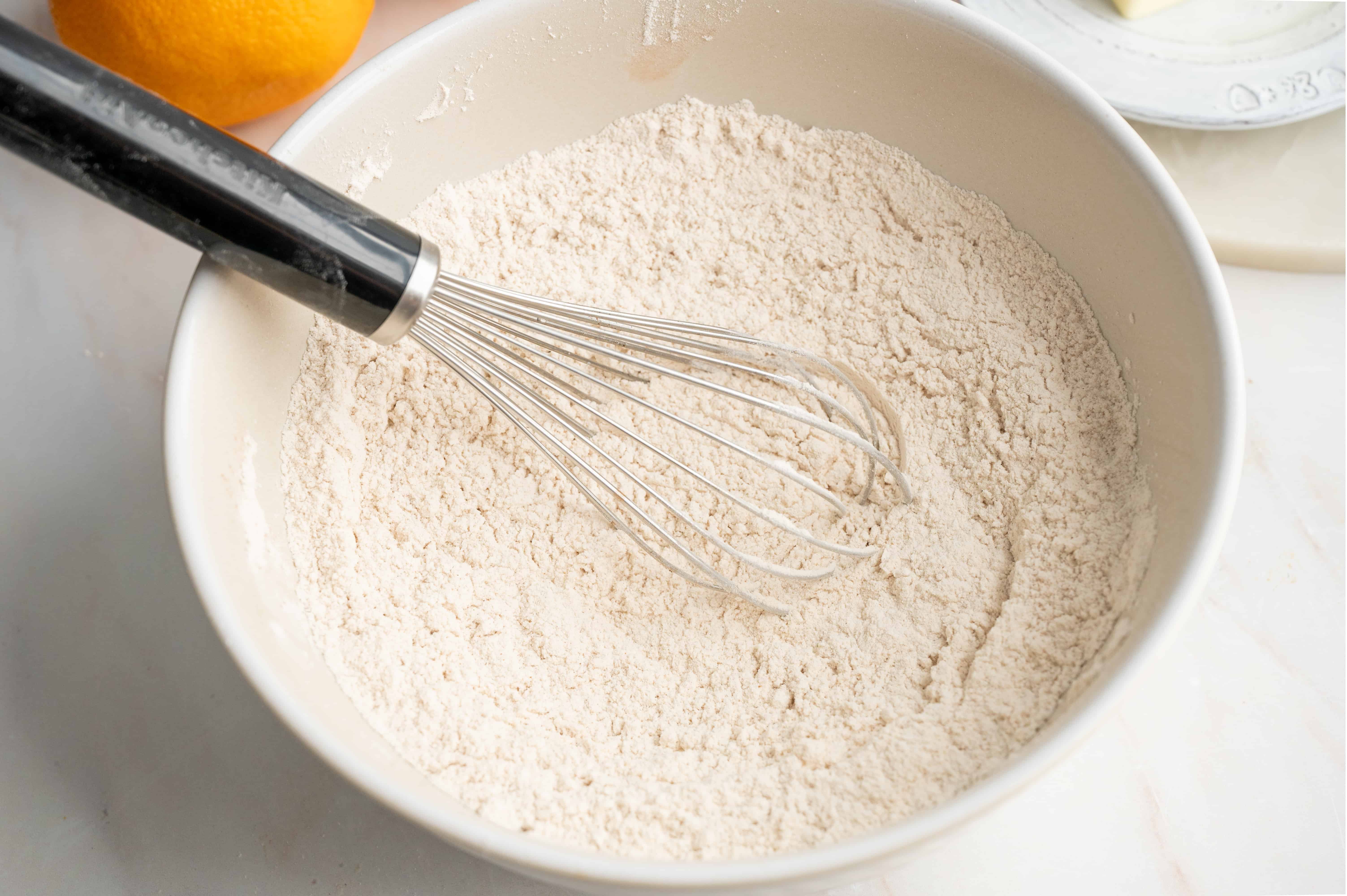 Flour and baking powder in a large bowl with a whisk