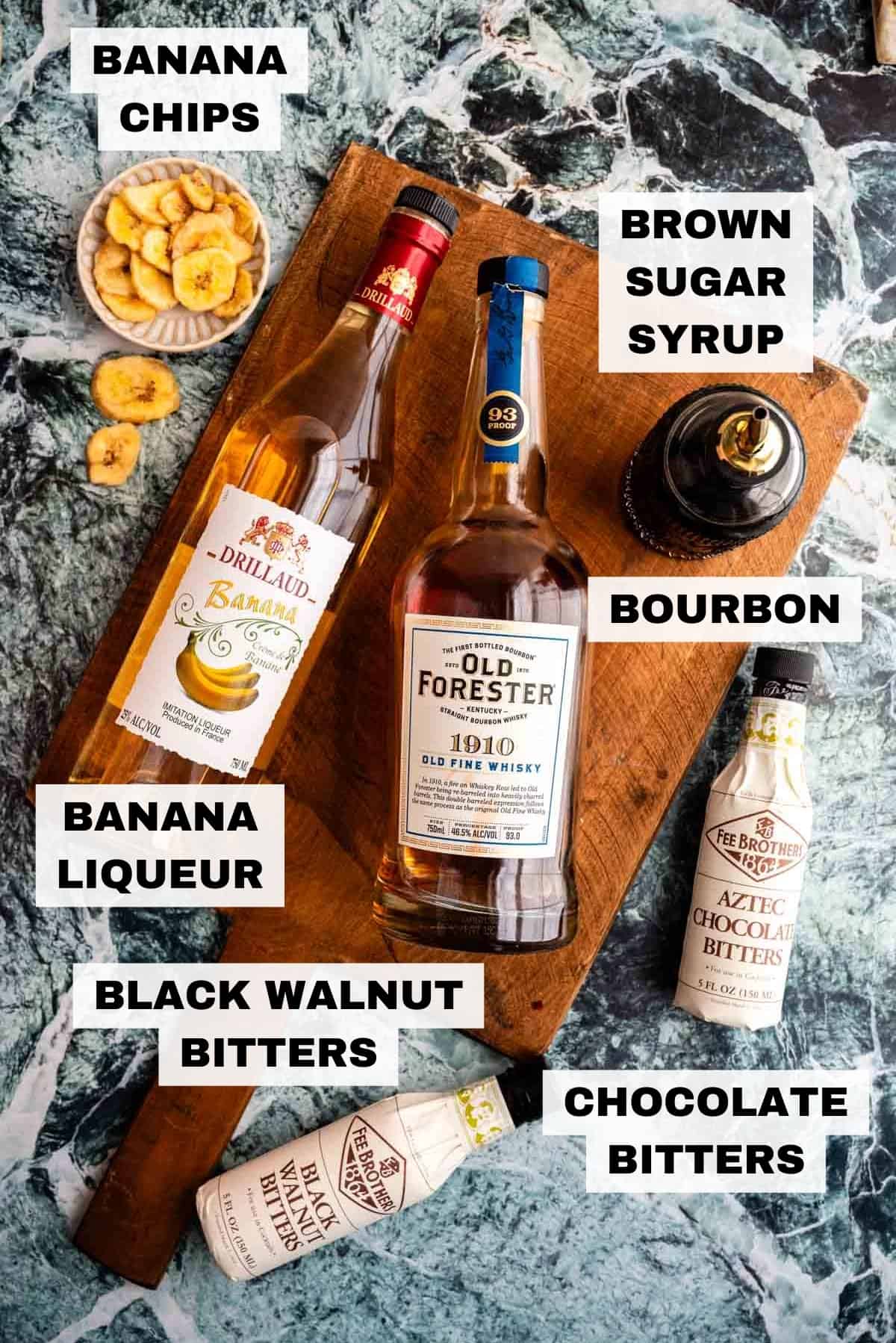 The ingredients for the banana old fashioned sitting on a green marble table.