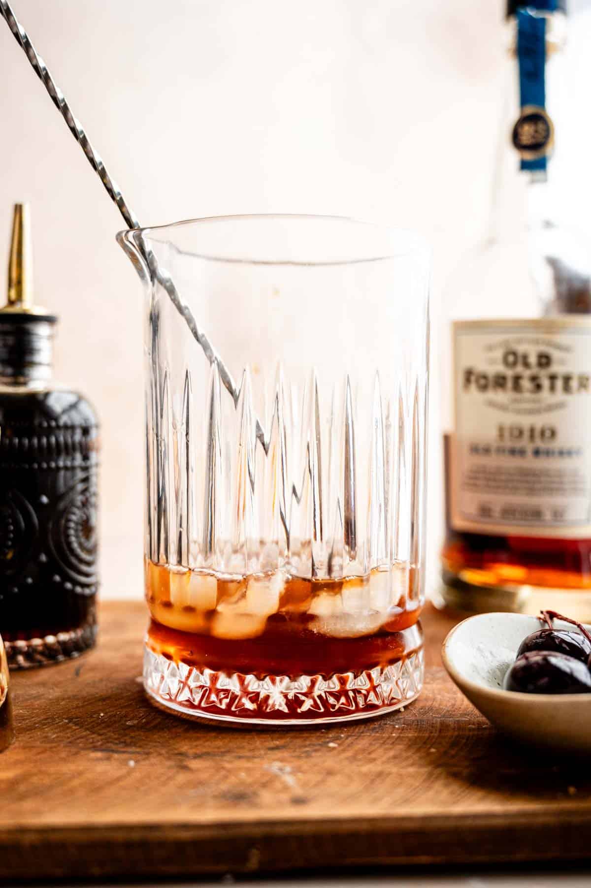 The bourbon, syrup, bitters, and ice in a mixing glass.