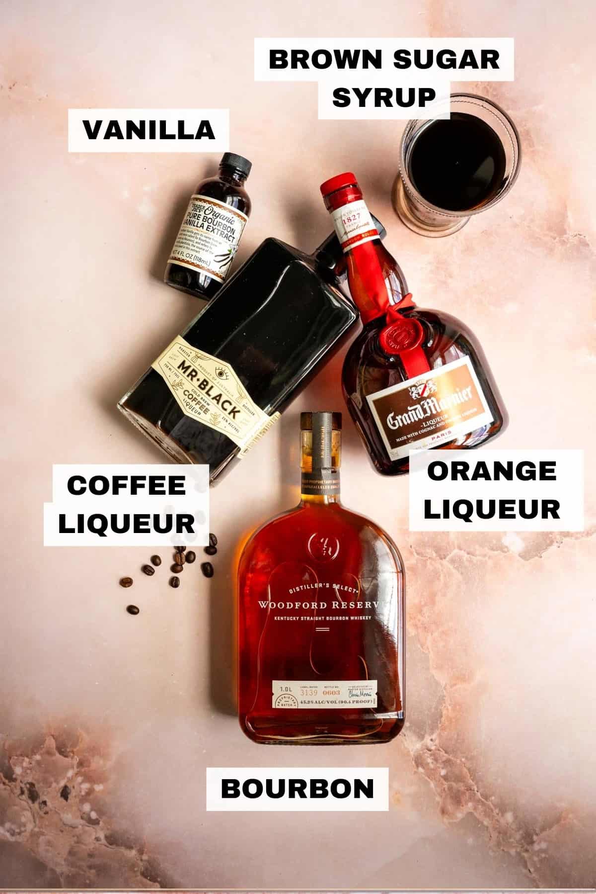 Ingredients for the bourbon espresso martini on a pink marble table.