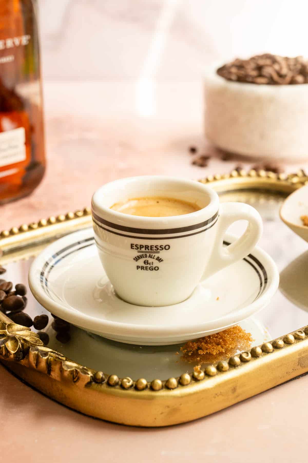 A shot of espresso on a mirrored tray.