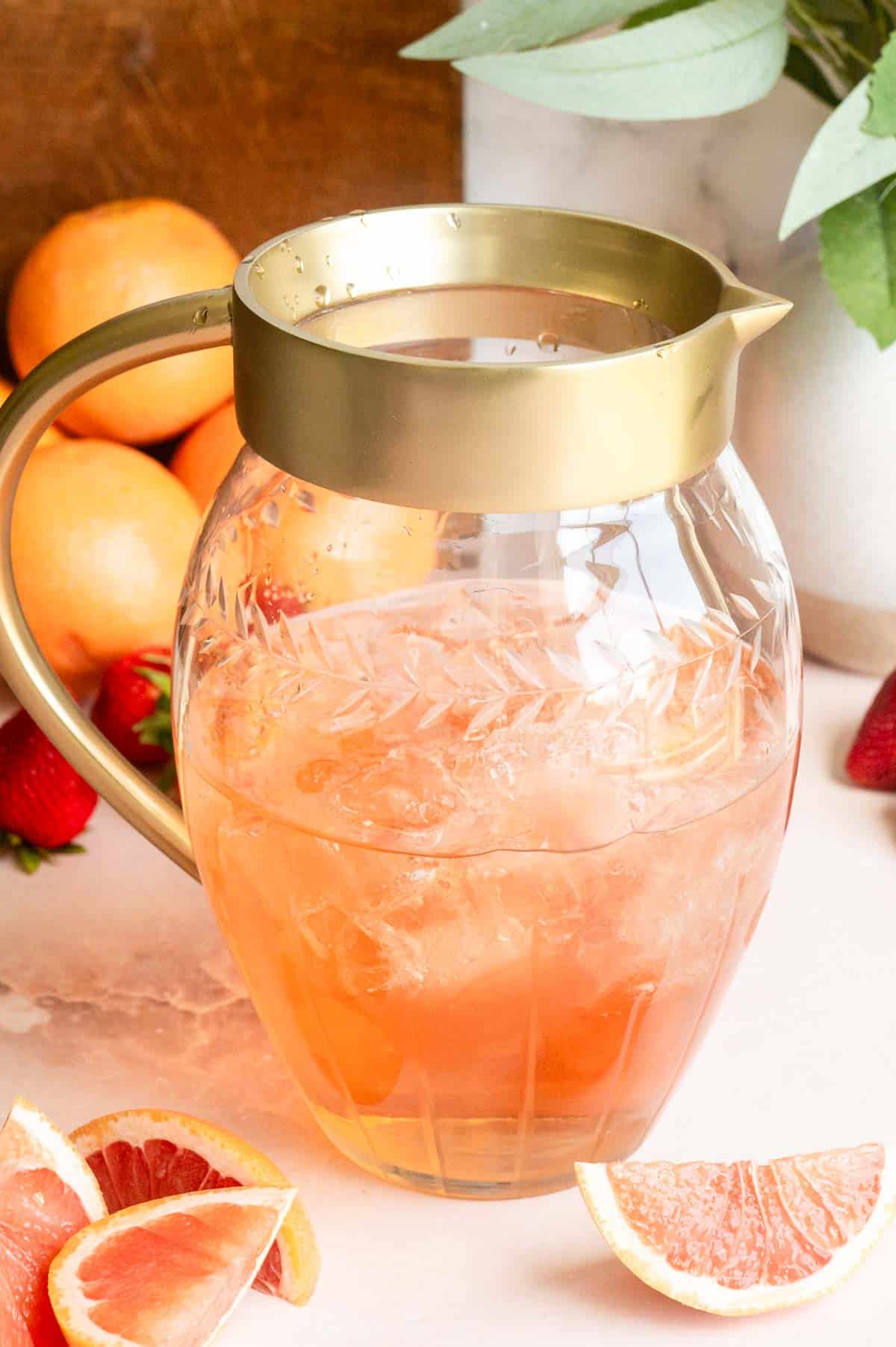 A glass pitcher filled with rose wine and ice.