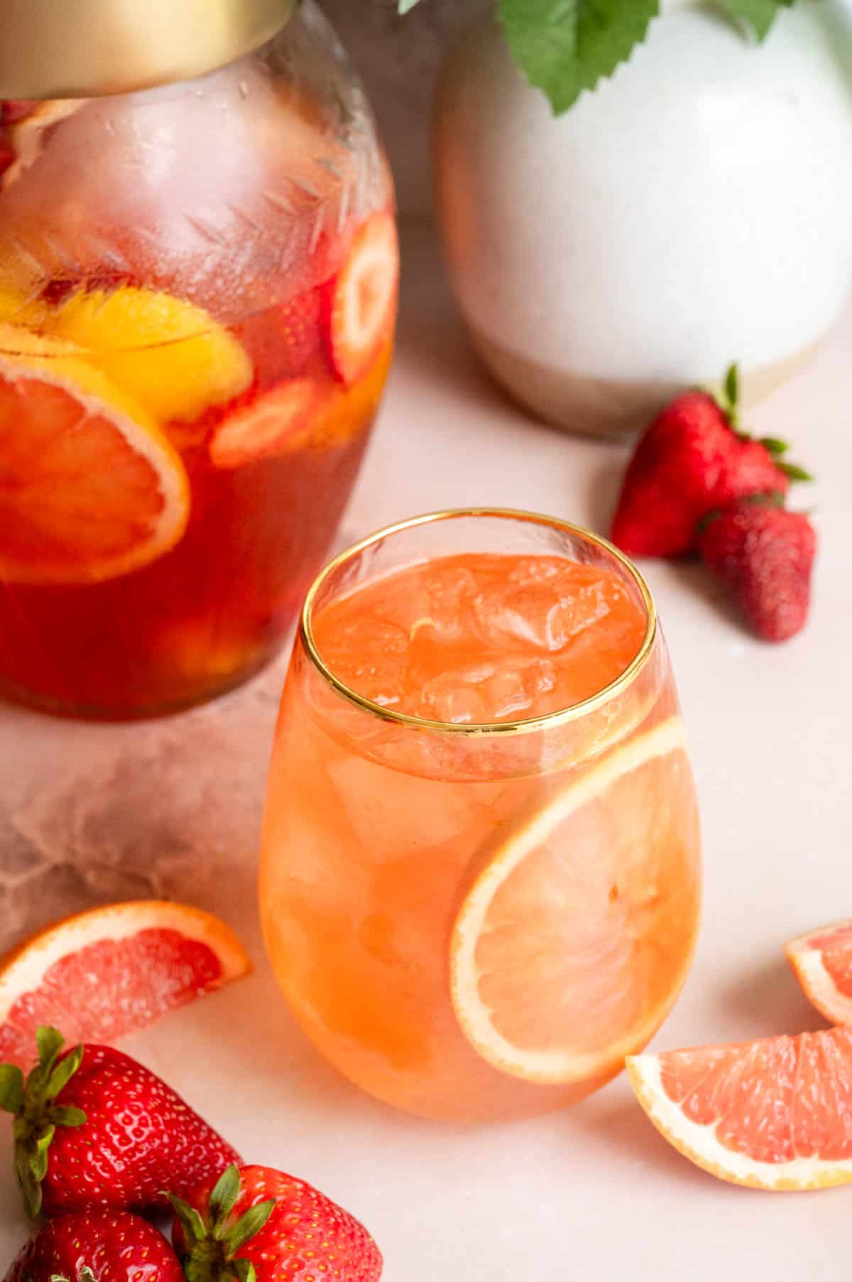 The sangria has been poured into a wine glass with a slice of grapefruit.