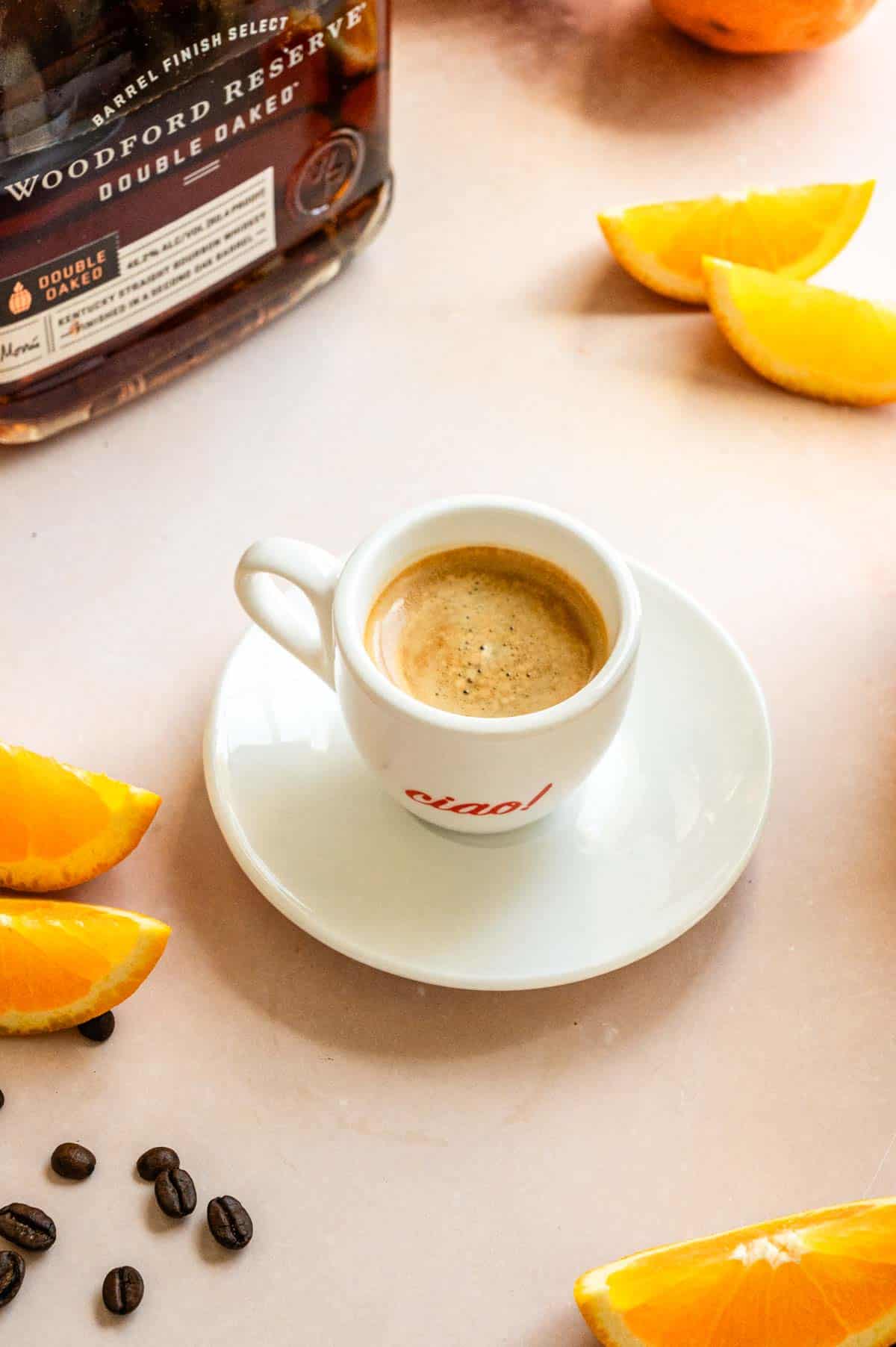 Brewed espresso in a cup and saucer on a pink marble table.