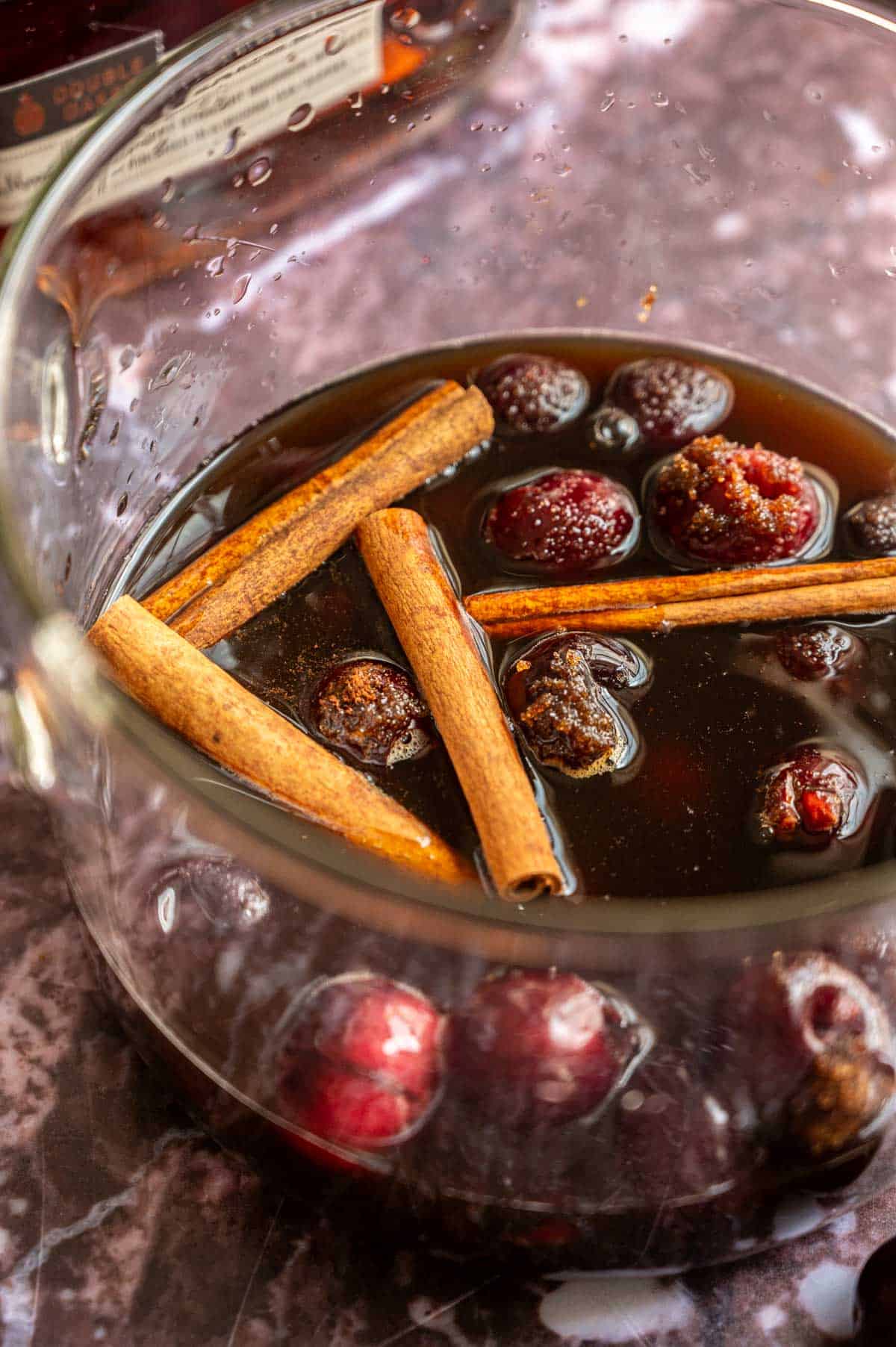 The spiced cherry syrup in a glass pot.