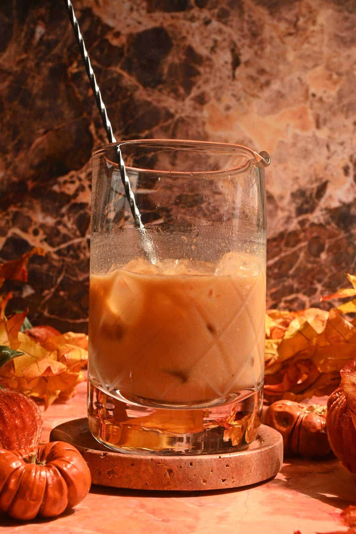 The stirred cocktail in a glass mixing glass.