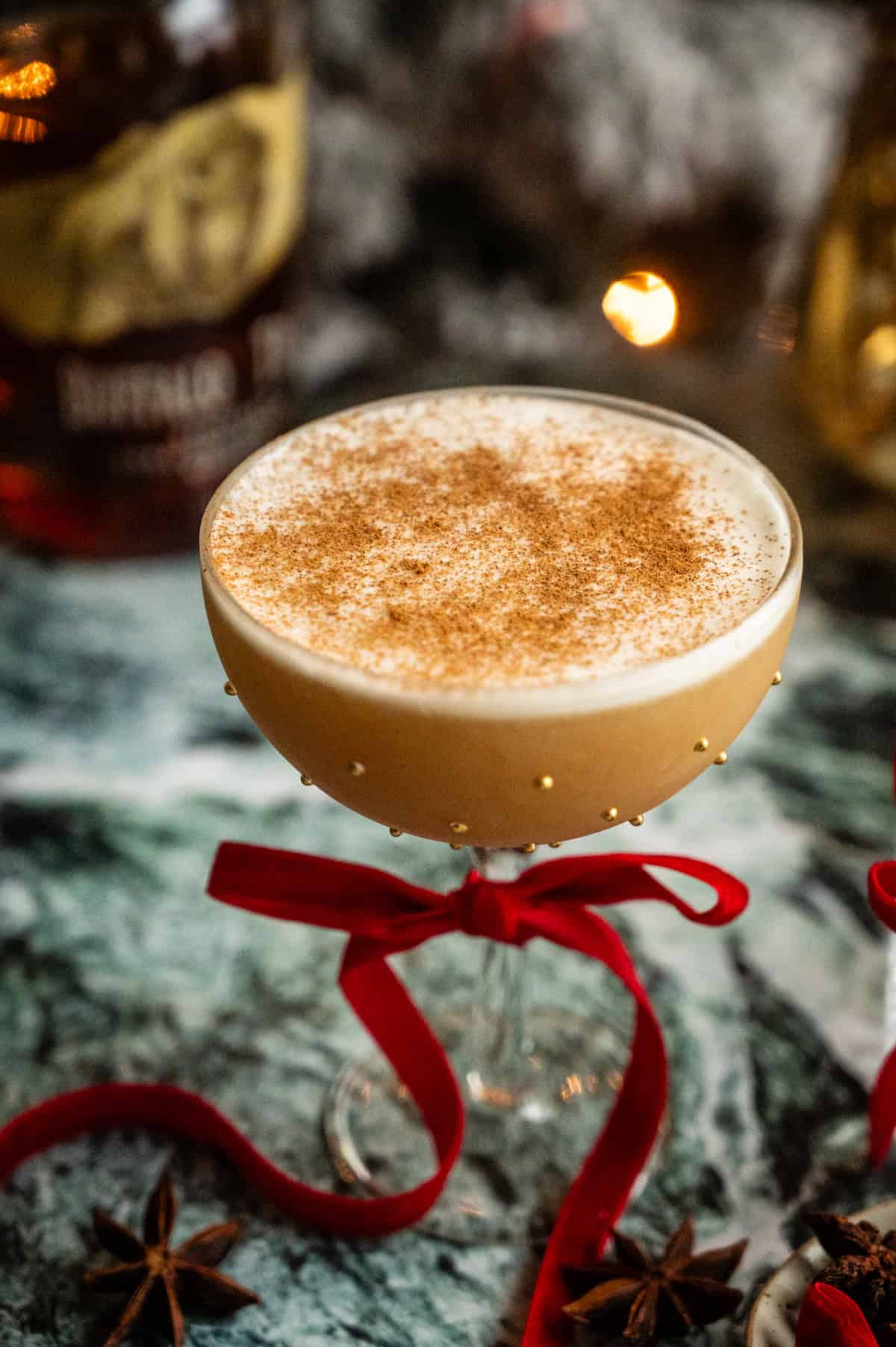 A coupe glass filled with the cocktail and dusted with cinnamon.