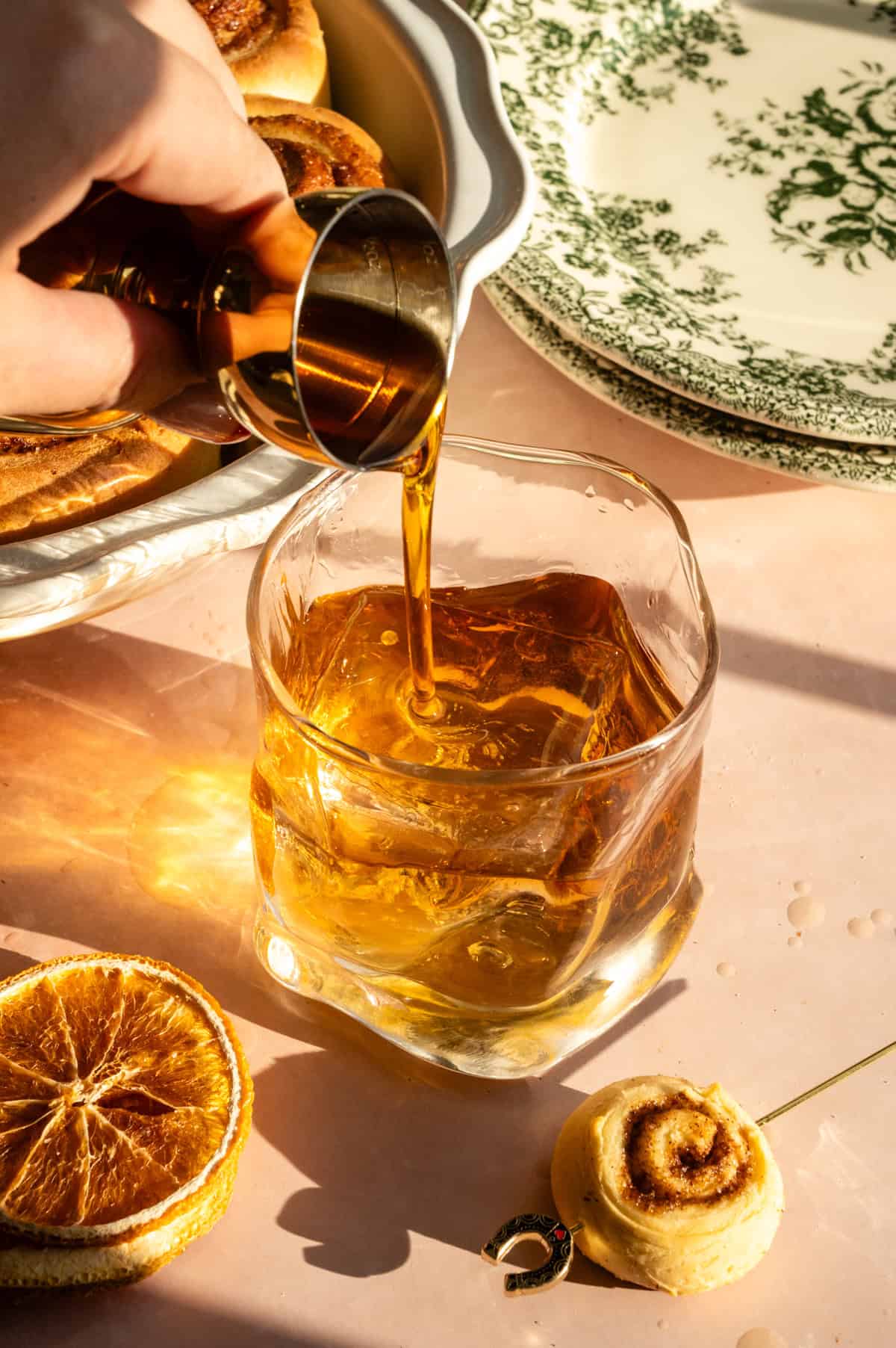 Maple syrup being poured into the rocks glass.