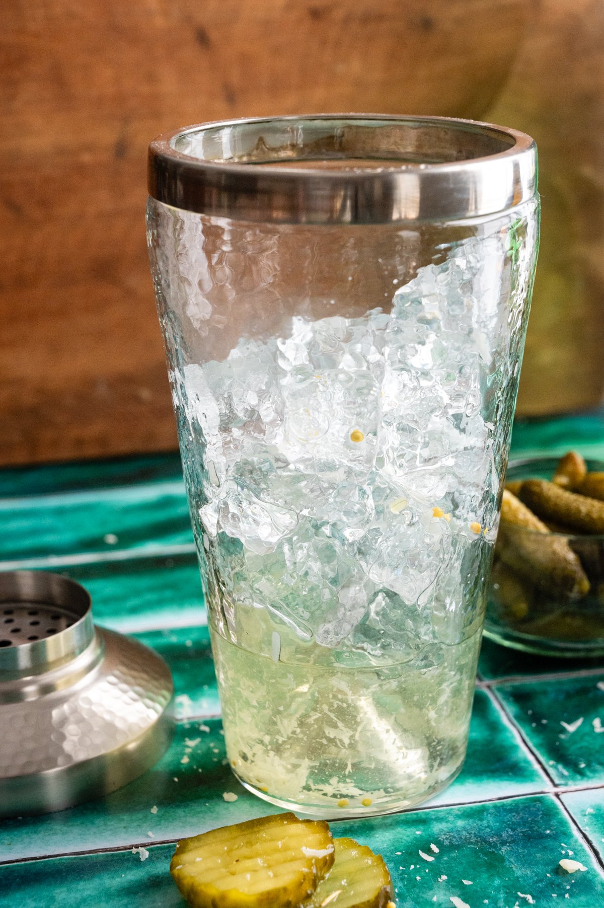 All the cocktail ingredients inside a cocktail shaker with ice.