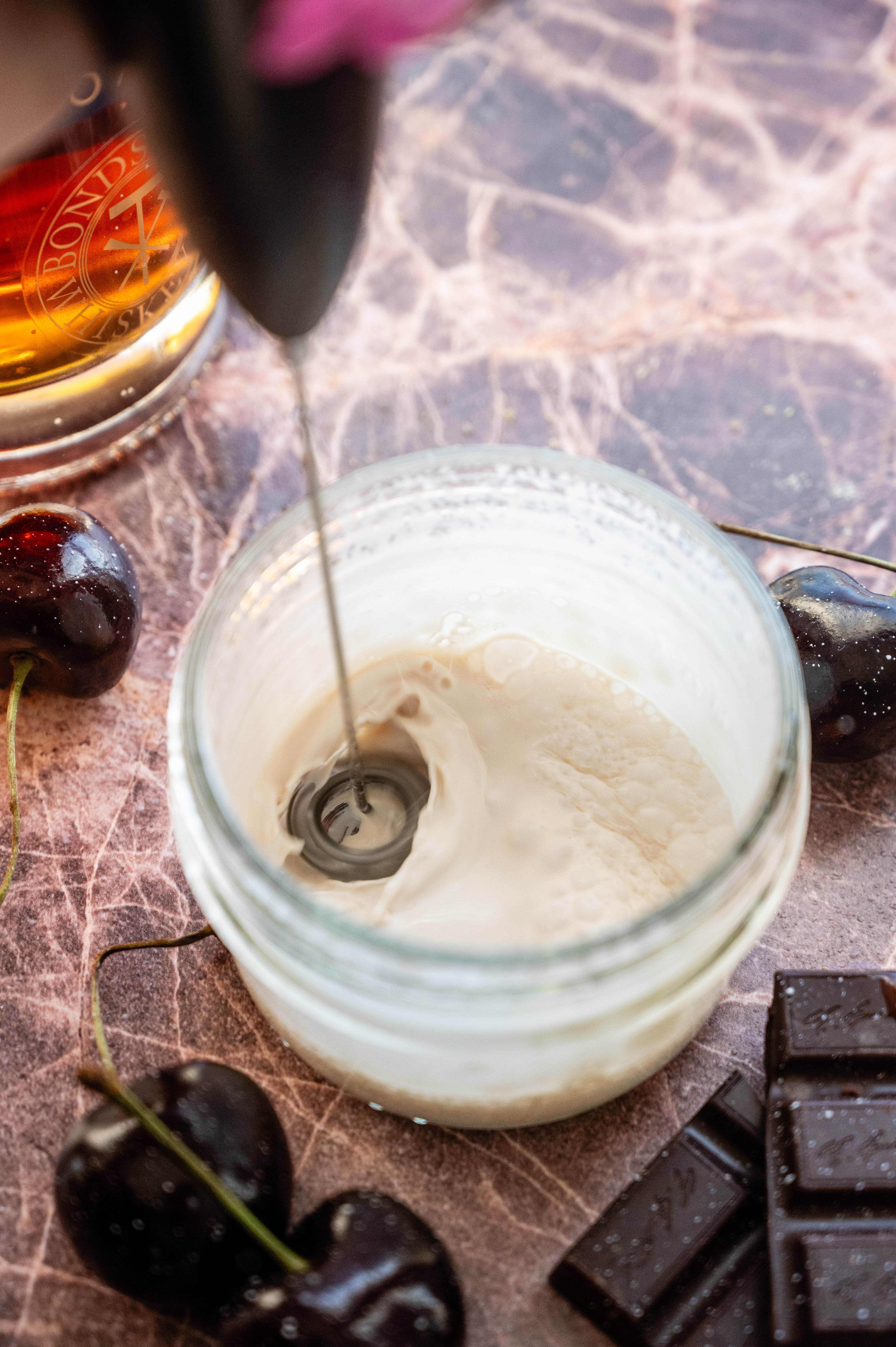 Cream being whisked into a small mason jar.