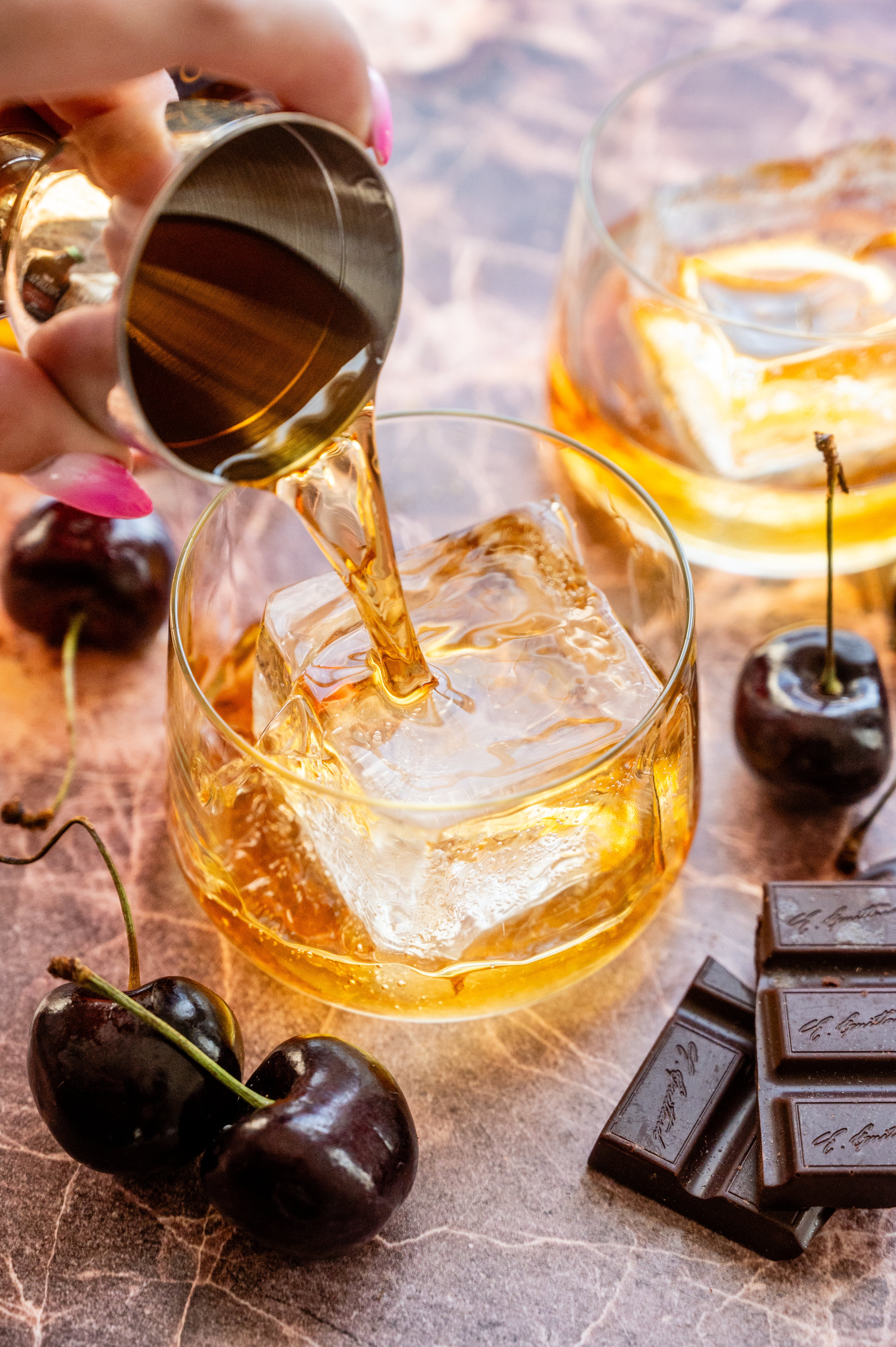 Bourbon being poured into a small rocks glass.