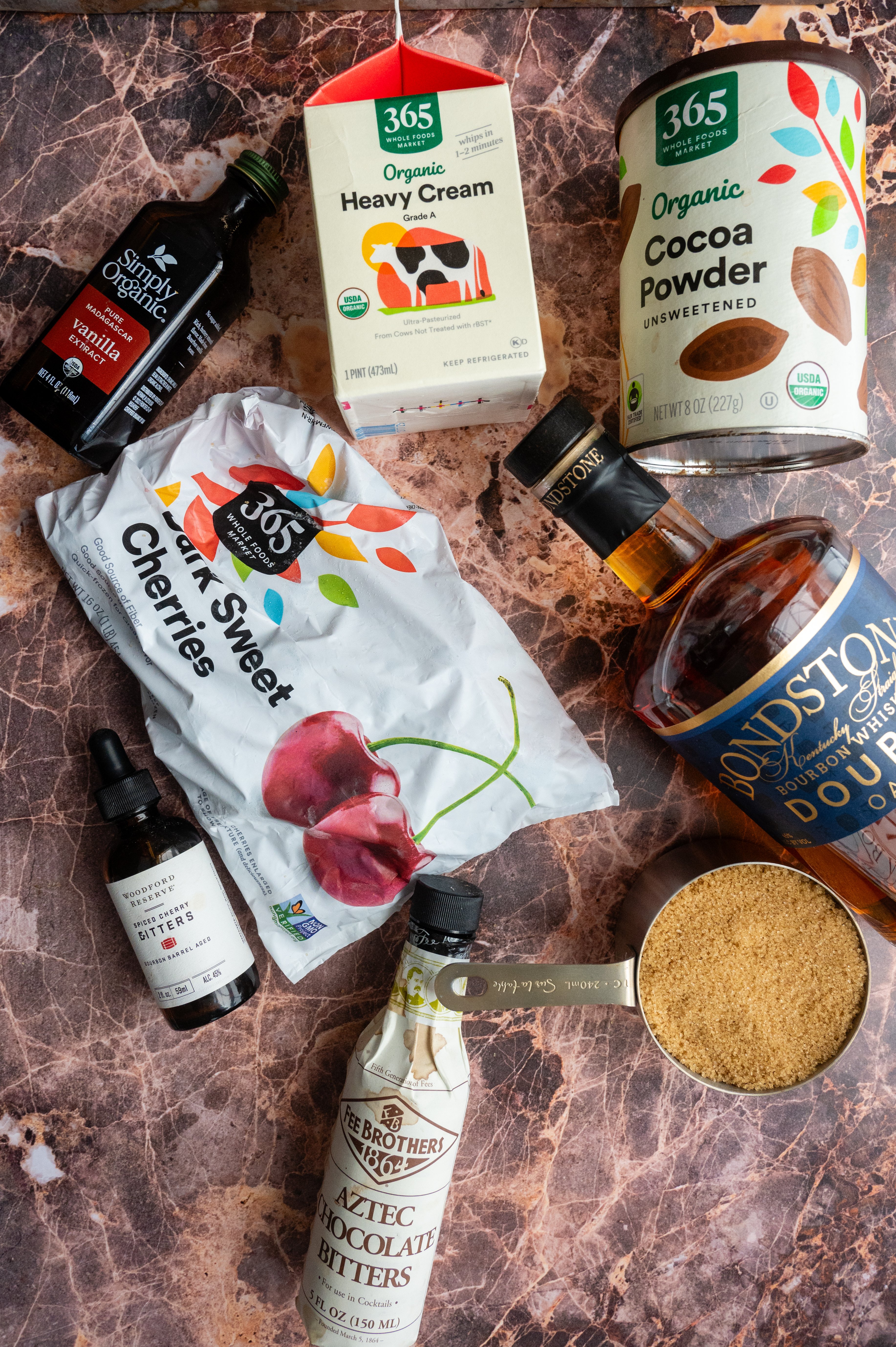 the ingredients for the drink on a pink marble table.